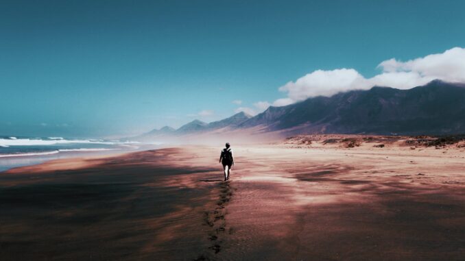 photo of person walking on deserted island
